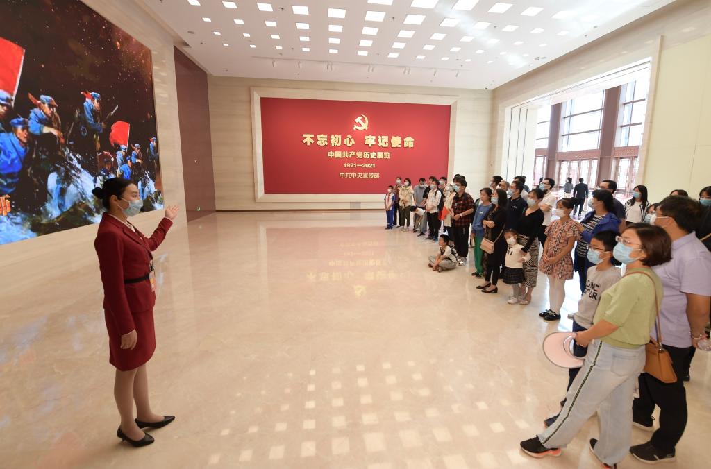 參觀者在中國共產(chǎn)黨歷史展覽館展廳聆聽工作人員講解（2021年10月1日攝）。新華社記者 李賀 攝